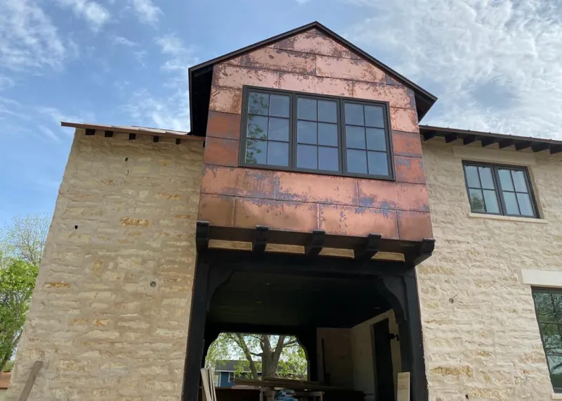 Copper metal panel facade on a stone building for Roof Repair in Bayou Blue