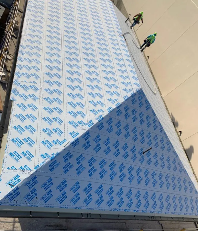 Professional roofers installing underlayment on a metal roof in Bayou Blue